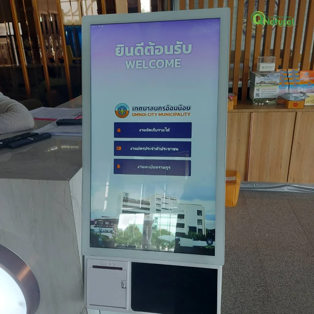 ตู้กดบัตรคิวหน้าจอสัมผัสตั้งพื้นที่เทศบาลนครอ้อมน้อย แสดงหน้าจอยินดีต้อนรับและปุ่มเลือกบริการ